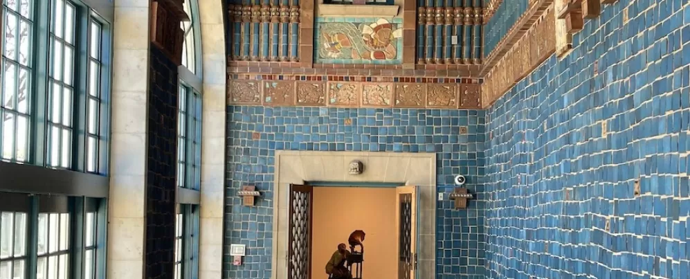 Vibrant tiled foyer at the Art Museum of the Americas with a sculpture visible through an open doorway.